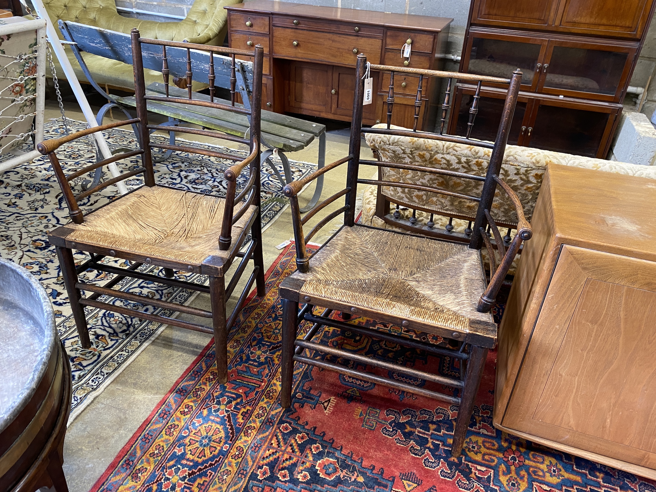 A pair of Arts & Crafts William Morris ash rush seat Sussex elbow chairs, width 58cm, depth 44cm, height 93cm